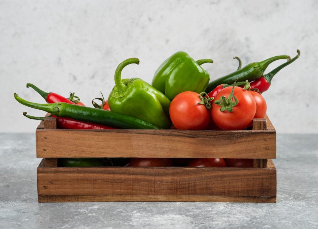 caja-de-madera-llena-de-verduras-frescas-en-marmol